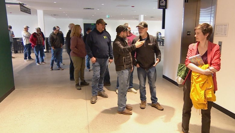 People stand in a line in a convention centre.