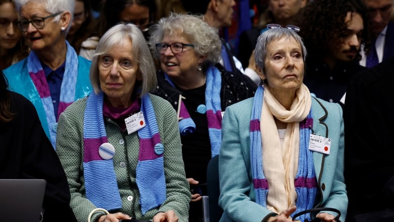 Four women who appear to be seniors are shown seated at an event.