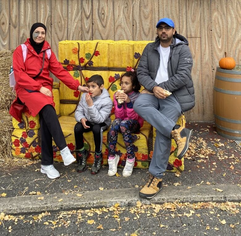 A family sits outdoors. 