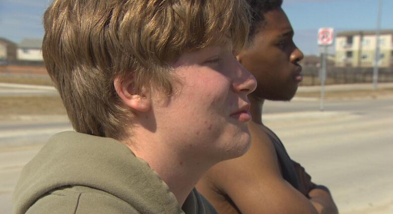 Two boys are pictured from the side, looking forward.