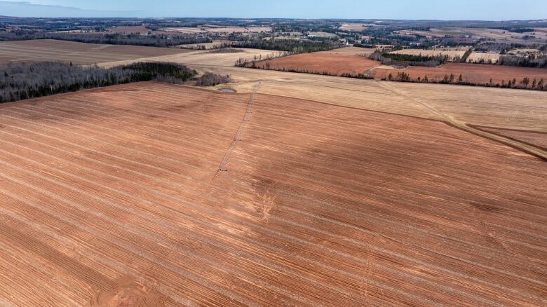 Farmers fields are seen with reddish-brown soil in spring