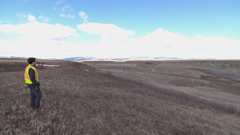 A man stands on a hillside.