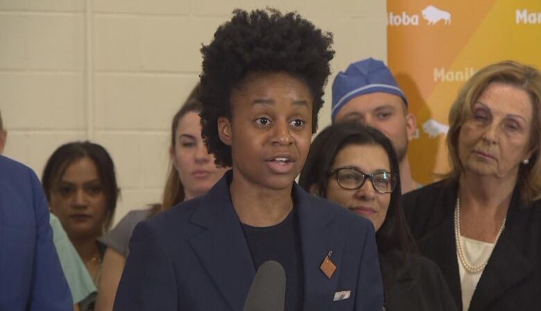 A person is pictured speaking at a podium.