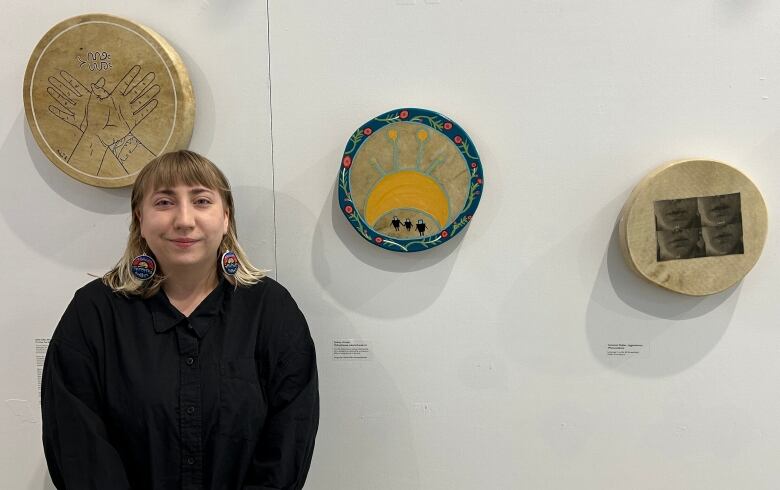 Woman standing with three drums surrounding her