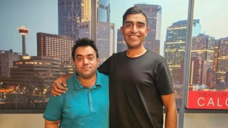 Two people are pictured standing side by side with a backdrop of a photo of the city of Calgary.