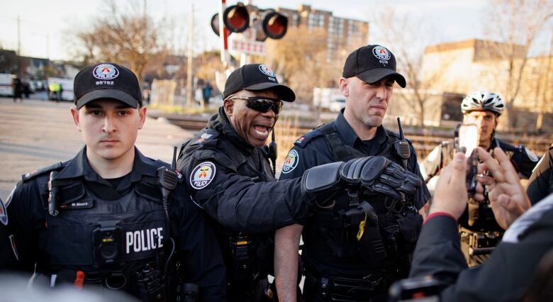 Toronto police face protesters at a rally organized by World Beyond War on April 16, 2024.