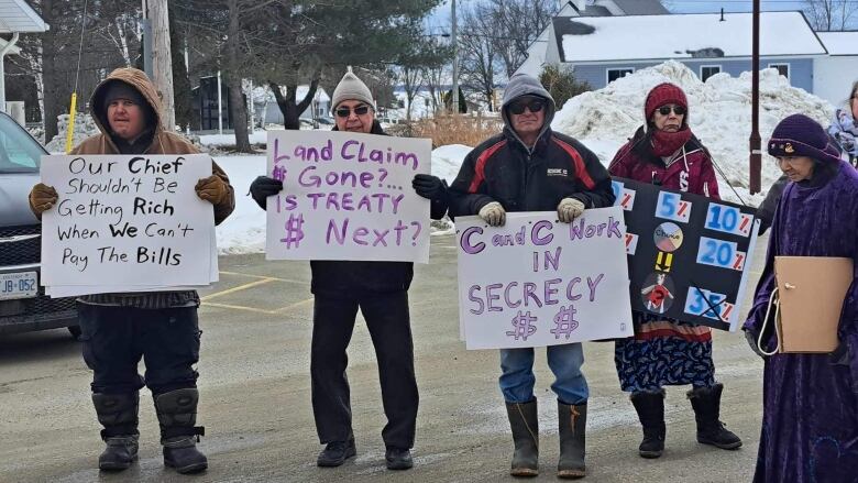 Indigenous people holding signs.