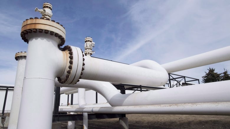 A complex arrangement of large, white pipes is seen against a blue sky.