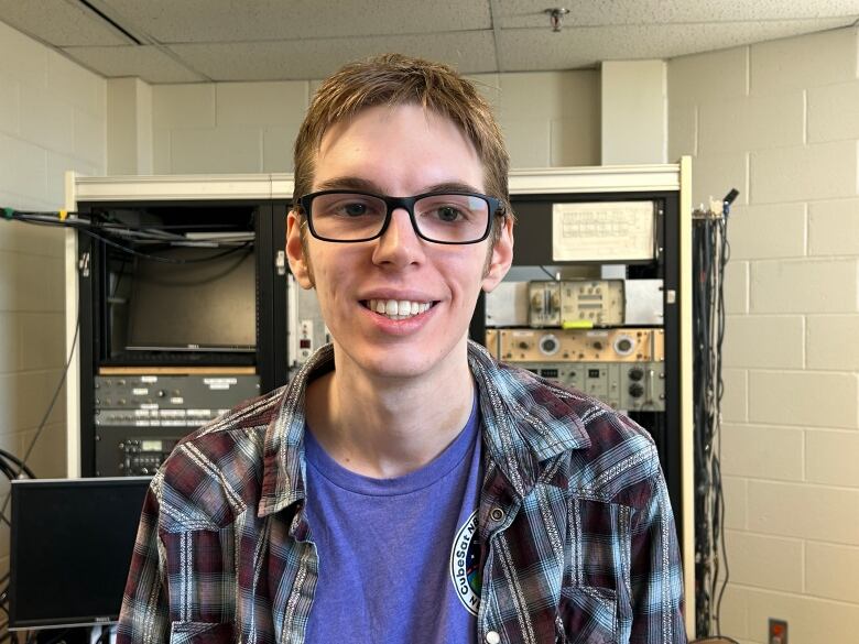 A white man wearing glasses. He has brown hair.