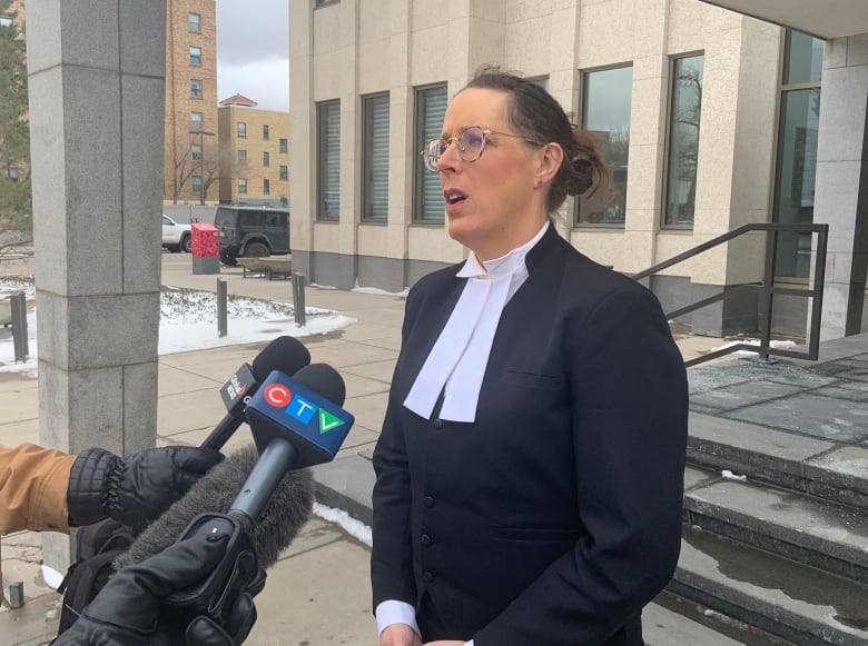 A Crown prosecutor speaks to reporters outside a courthouse. 