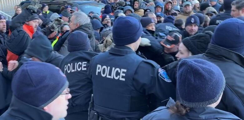 a crowd of protesters and police tussle