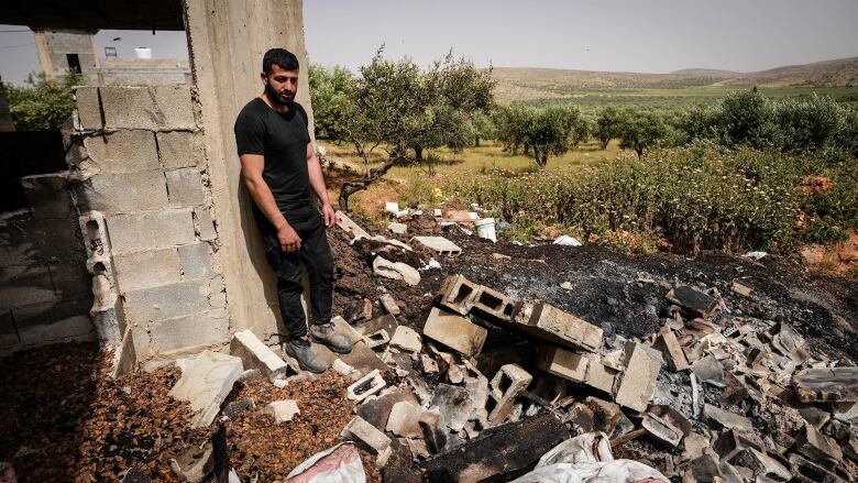 A person looks over rubble remaining after a building was destroyed.