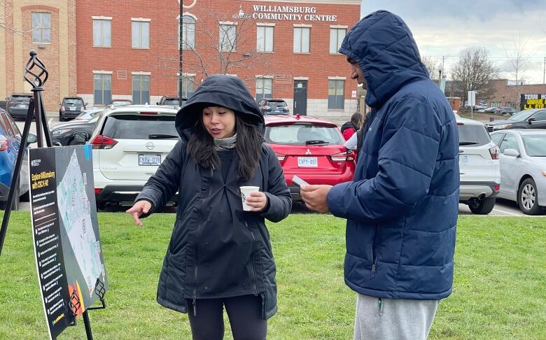 Young woman points to a map while talking with a man