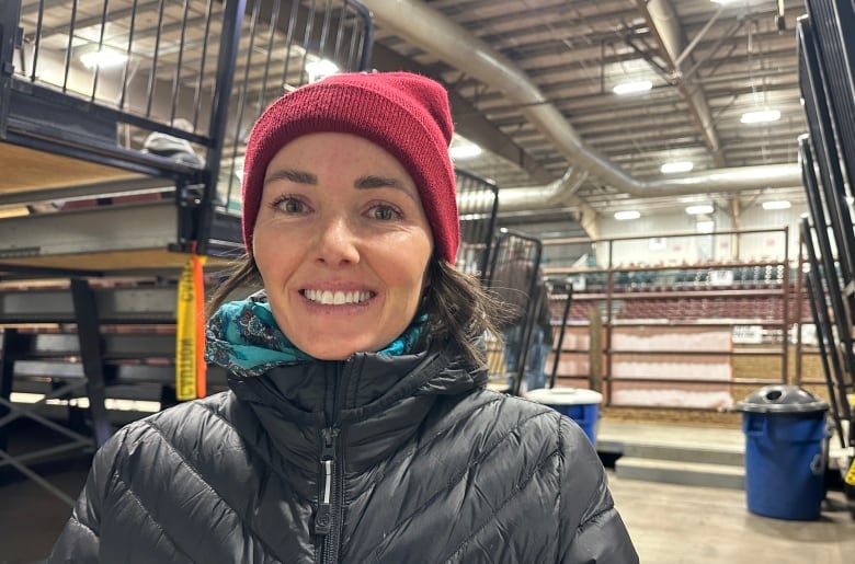 A woman wearing a tuque stands outside the arena in Medicine Hat.