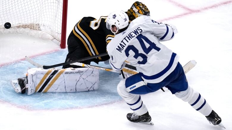 Toronto Maple Leafs center Auston Matthews (34) beats Boston Bruins goaltender Linus Ullmark, back, for a goal during the third period of Game 2 of an NHL hockey Stanley Cup first-round playoff series, Monday, April 22, 2024, in Boston. (AP Photo/Charles Krupa)