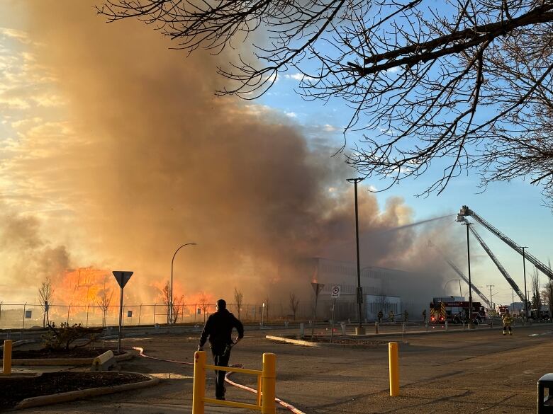 Flames and smoke with a person silhouetted in front.