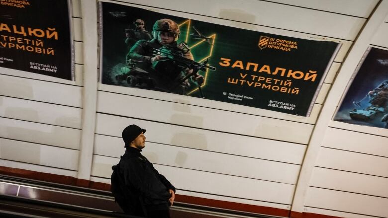 A wartime military enlistment advertisement is seen at a metro station in Kyiv, Ukraine.