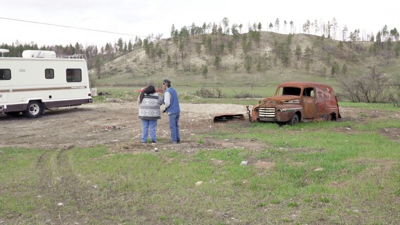 Pete and Dolly Andrew are pictured at the edge of their property in Aq'am in April of 2024. They look out on what is now a patch of bare land, where their home once stood. They are one of seven families that lost their homes to the St. Mary's River Wildfire in July of 2023. 