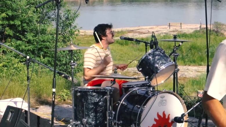 A drummer sings and plays in a rock band.