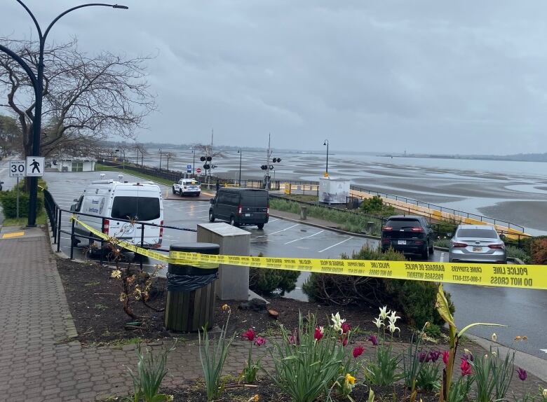 police tape around a parking lot beside a beach