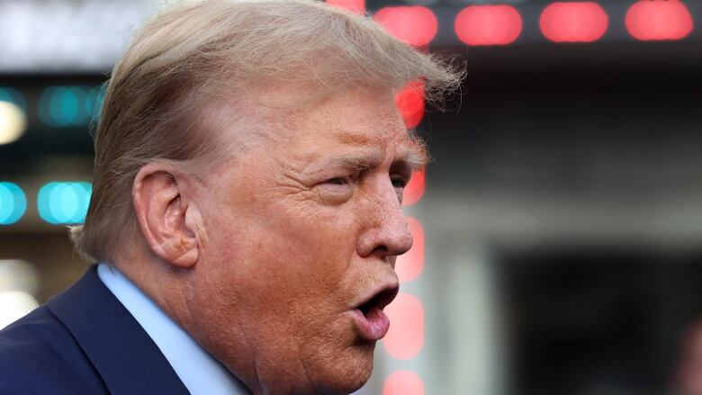 Former U.S. president Donald Trump speaks to members of the media outside a New York bodega.