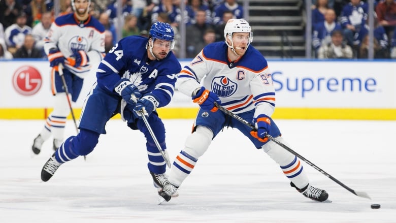 A hockey player backchecks against an opponent.