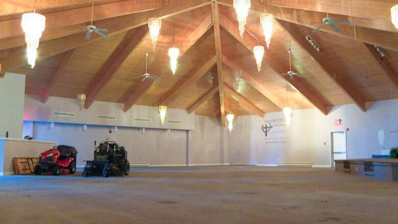 A empty church nave with a couple pieces of machinery in the far left corner.