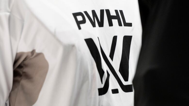 A close-up of a women's hockey jersey displaying the PWHL logo is shown.