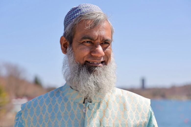 A man in traditional Bangladeshi dress with a beard and taqiyah.