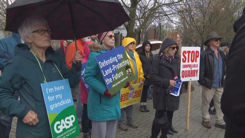 People holding signs against the Campbellville Quarry or depict them in support of protecting the environment. 