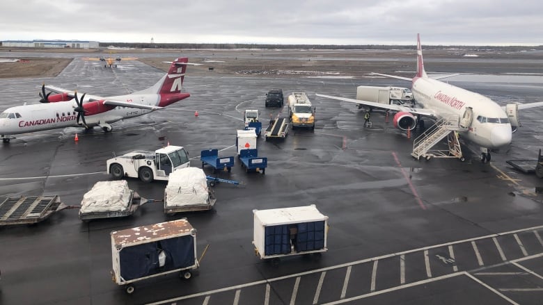 Many planes and trucks outside the airport