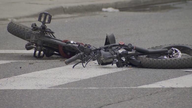 An eye bike lying on the ground at an intersection.