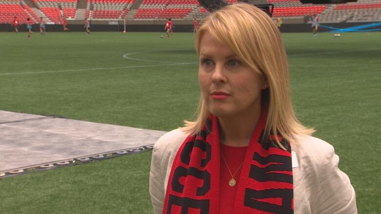 A woman with blonde hair and a red scarf