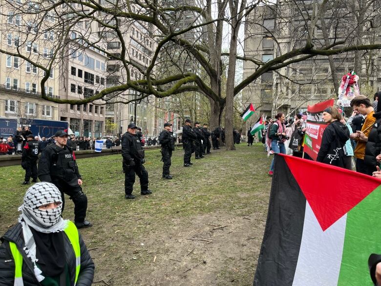 a line of police separates two groups