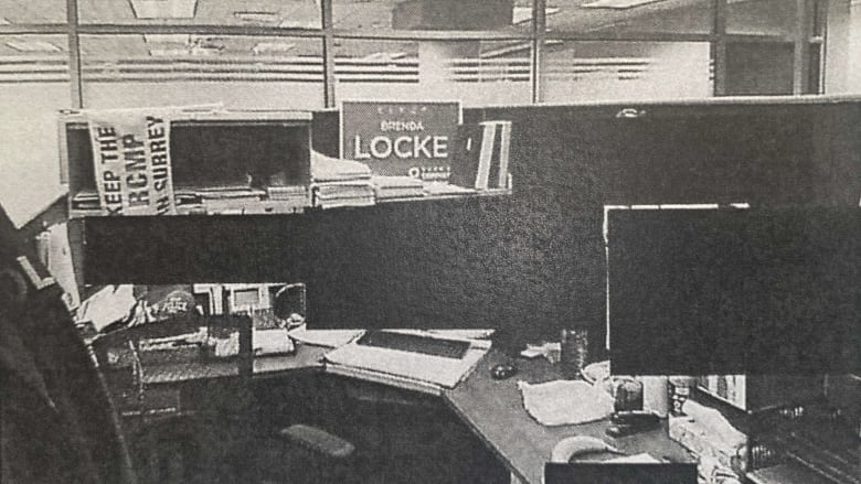 A photograph included in an investigative report detailing allegations of harassment by RCMP officers against Surrey Police Service members shows the workplace of a senior officer who kept a 'Keep The RCMP in Surrey' sign on his desk as well as an election sign for Mayor Brenda Locke.