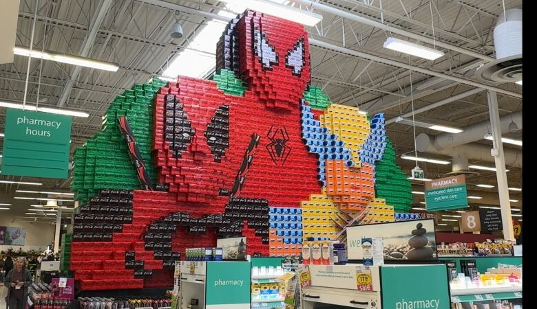 A colorful display made using soda boxes of Spider-Man at a grocery store.