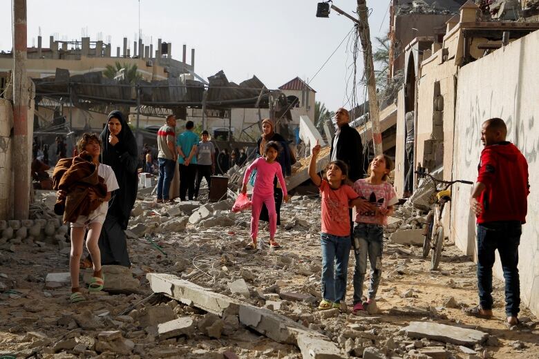 People standing amid survey the damage.