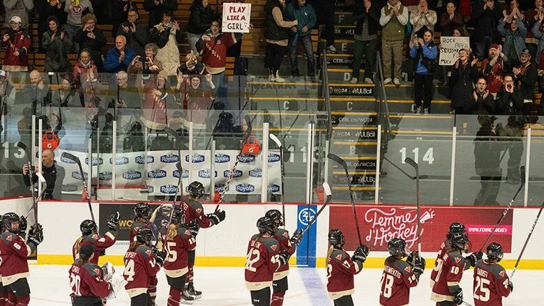 Members of PWHL Montreal, dressed in burgundy, sand and storm uniforms, salute the home crowd following a womens hockey game on April 24, 2024.