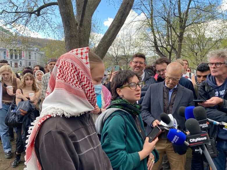 A group of people around microphones outdoors.