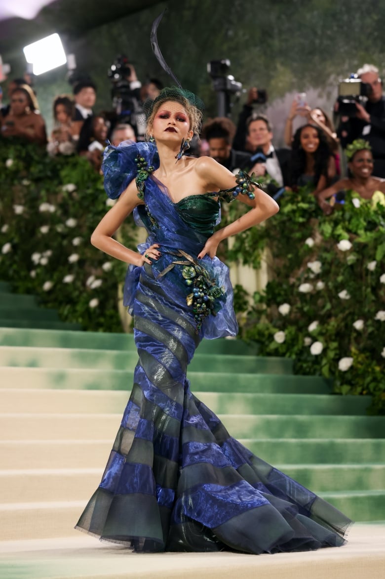 Zendaya on the 2024 Met Gala red carpet wearing a blue and green one-shoulder, mermaid-hem gown.