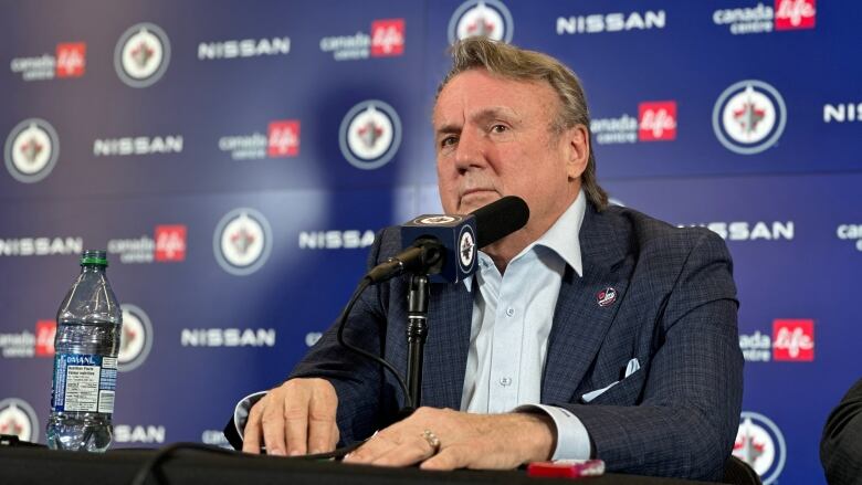 A man sitting at a table at a news conference.