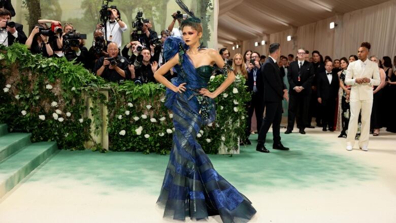 Zendaya on the 2024 Met Gala red carpet wearing a blue and green one-shoulder, mermaid-hem gown. 