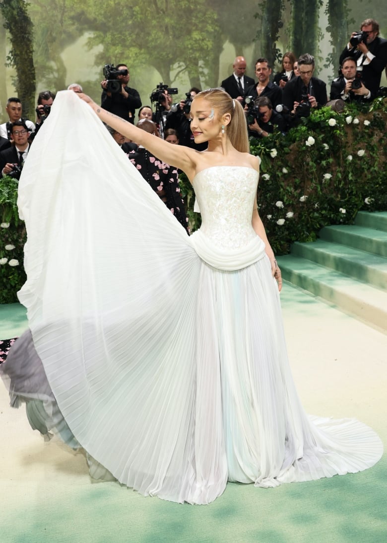 Ariana Grande on the Met Gala red carpet wearing a strapless dress with a shimmery, mother-of-pearl bodice.