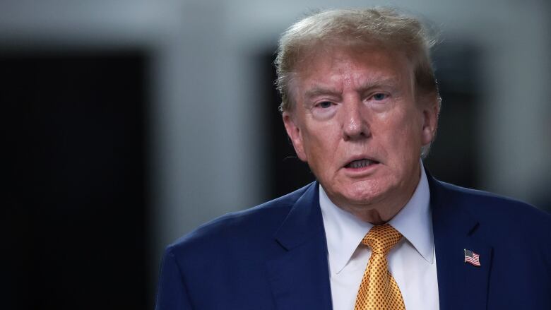 Former U.S. president Donald Trump is seen walking en route to speak with members of the media in New York City.