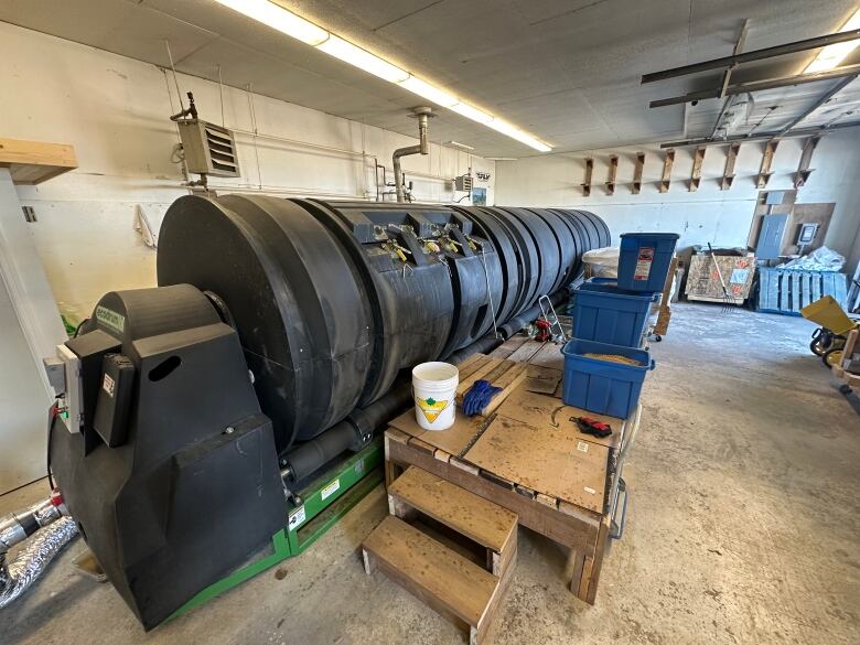 A big black cylinder in a building. It looks a bit like the locomotive of a train. 