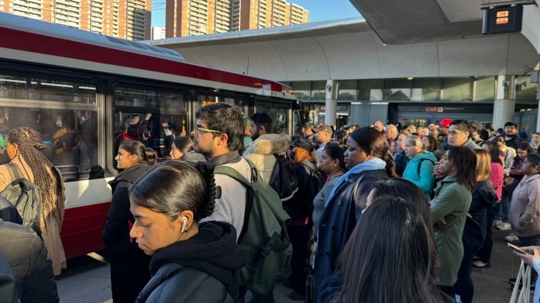 Commuters line up for buses at Victoria Park subway station on Thursday morning, where Line 2 trains are turning back due to a technical issue.