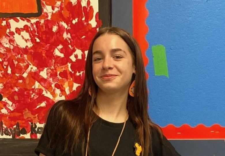 Layla Rodgerson poses for a photo wearing a black shirt and red dress.