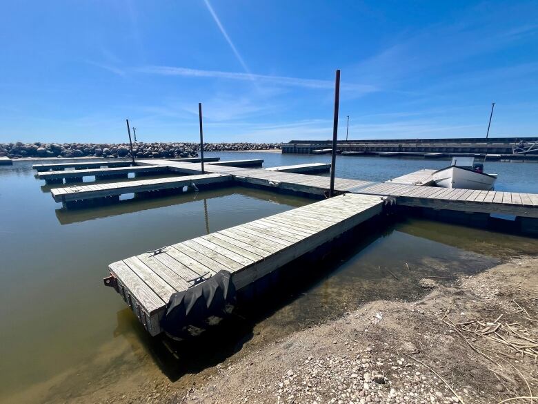 A floating boat dock, with gravel and sand in the foreground.