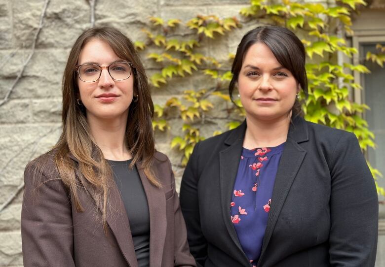 Two teachers pose for a photo outside.