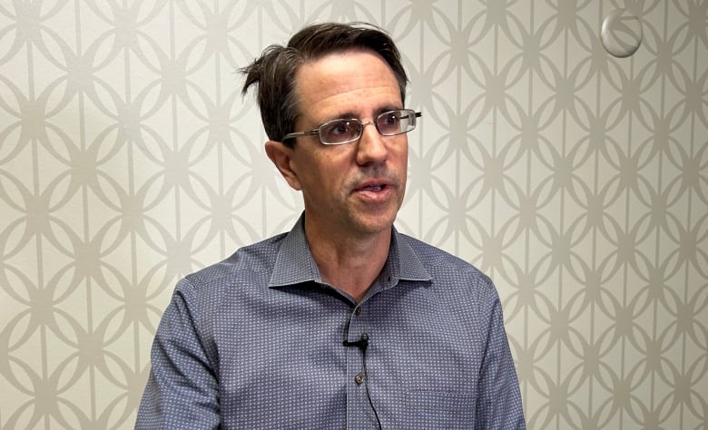 A man with glasses in a collared shirt. 